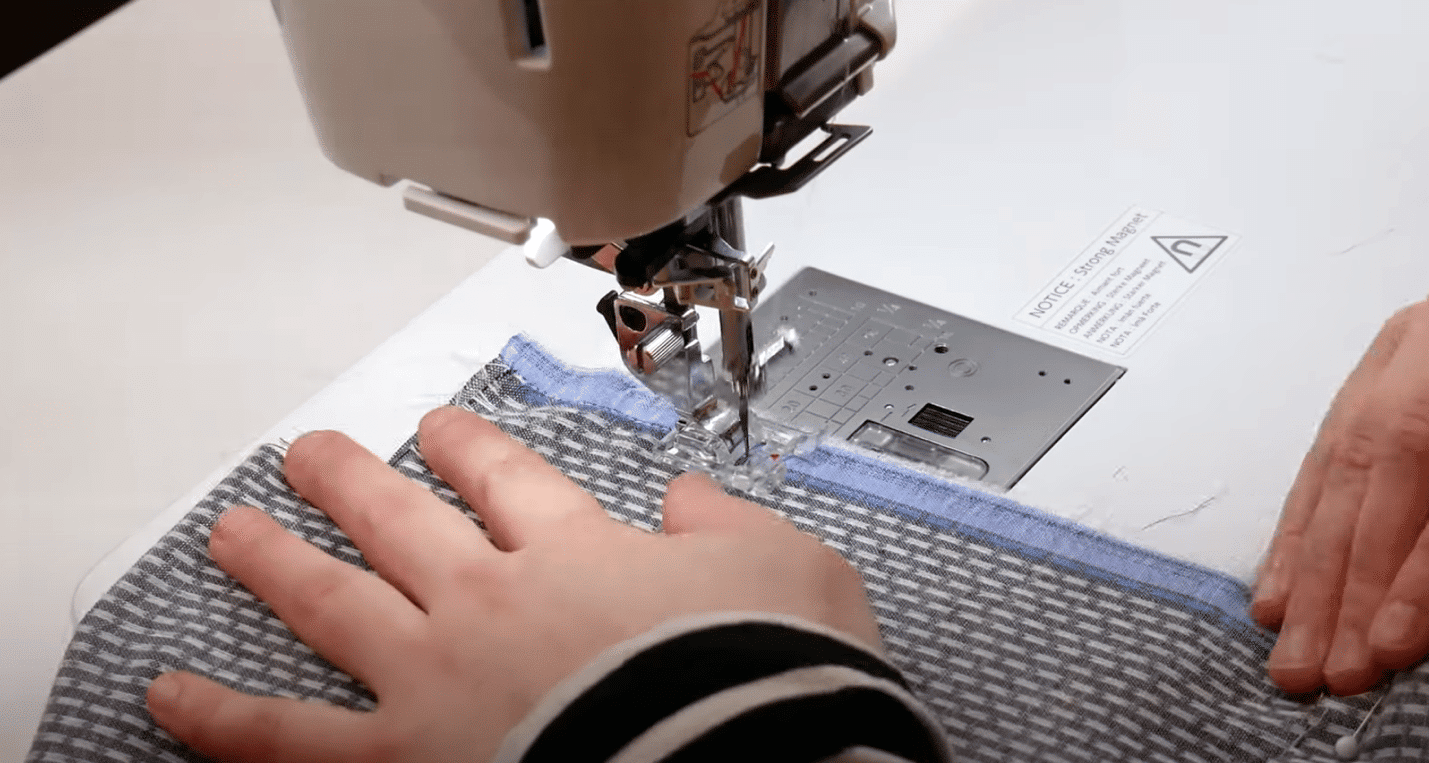 A picture containing person, sewing machine, indoor, appliance Description automatically generated